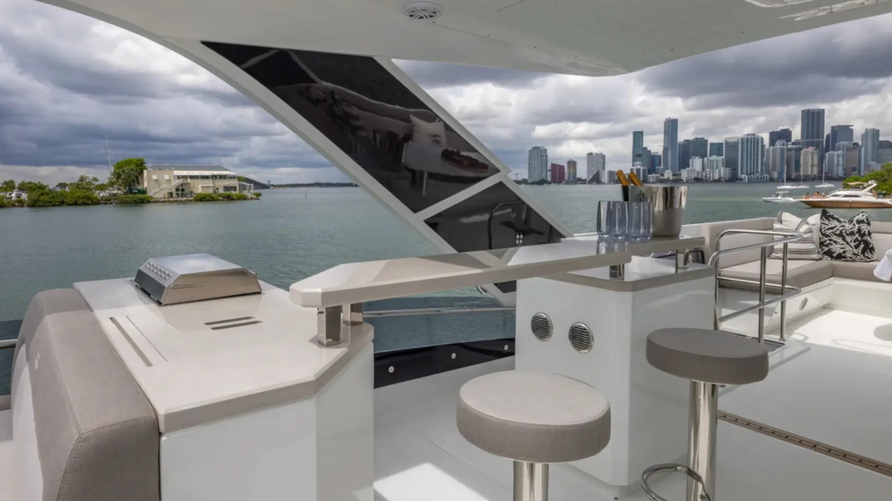 68' Galeon Yacht Charter featuring the aft deck bar seating outdoor grill and panoramic Downtown Miami skyline while cruising near Key Biscayne on Biscayne Bay.
