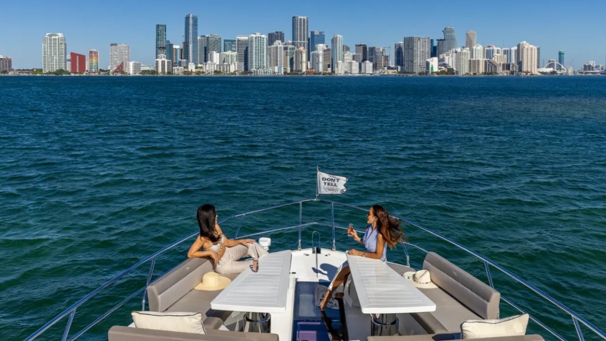 68' Galeon Yacht Charter featuring the spacious bow lounge with panoramic Downtown Miami skyline views while anchored near Key Biscayne on Biscayne Bay.