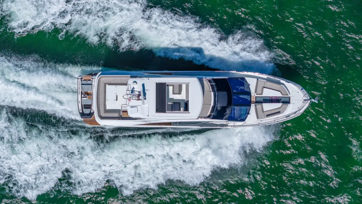 68' Galeon Yacht Charter captured from an overhead drone perspective cruising across Biscayne Bay with foaming wake showcasing the full yacht layout near Key Biscayne.