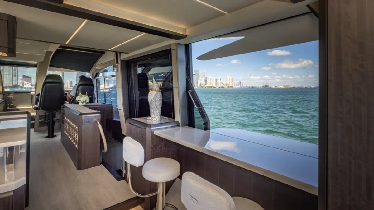 68' Galeon Yacht Charter featuring the retractable side window connecting the salon and side terrace with panoramic Biscayne Bay views near Key Biscayne.