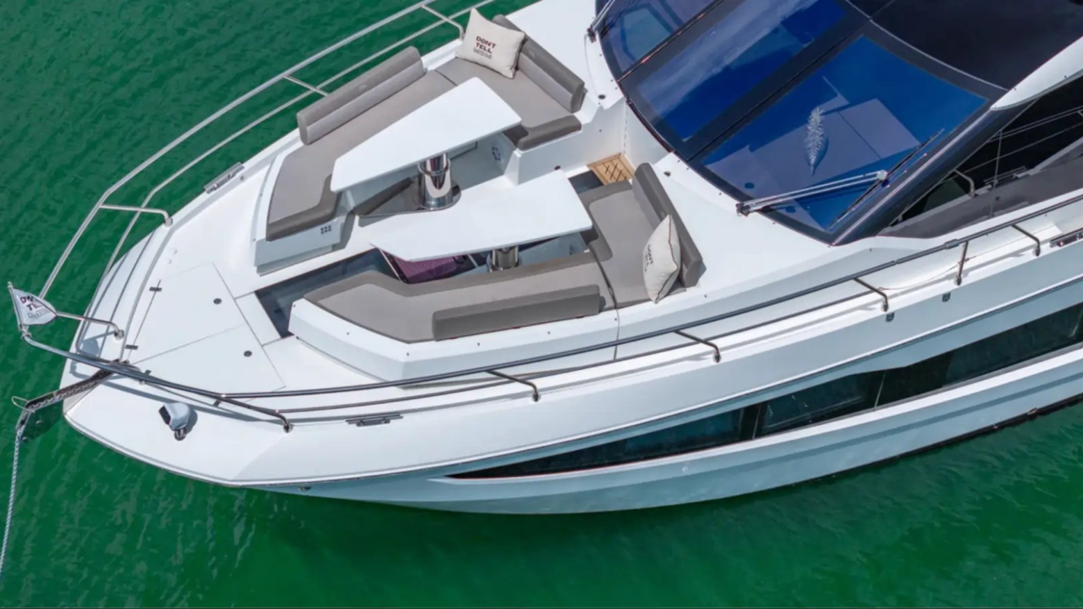 68' Galeon Yacht Charter captured from a top-down aerial highlighting the spacious bow lounge with dual convertible tables and wraparound seating anchored near Key Biscayne on Biscayne Bay.