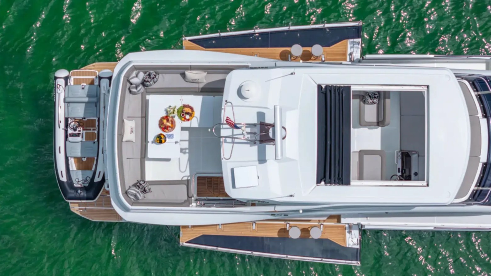 68' Galeon Yacht Charter captured from a top-down drone shot highlighting the flybridge lounge aft deck and expansive side walkways while cruising off Key Biscayne on Biscayne Bay.