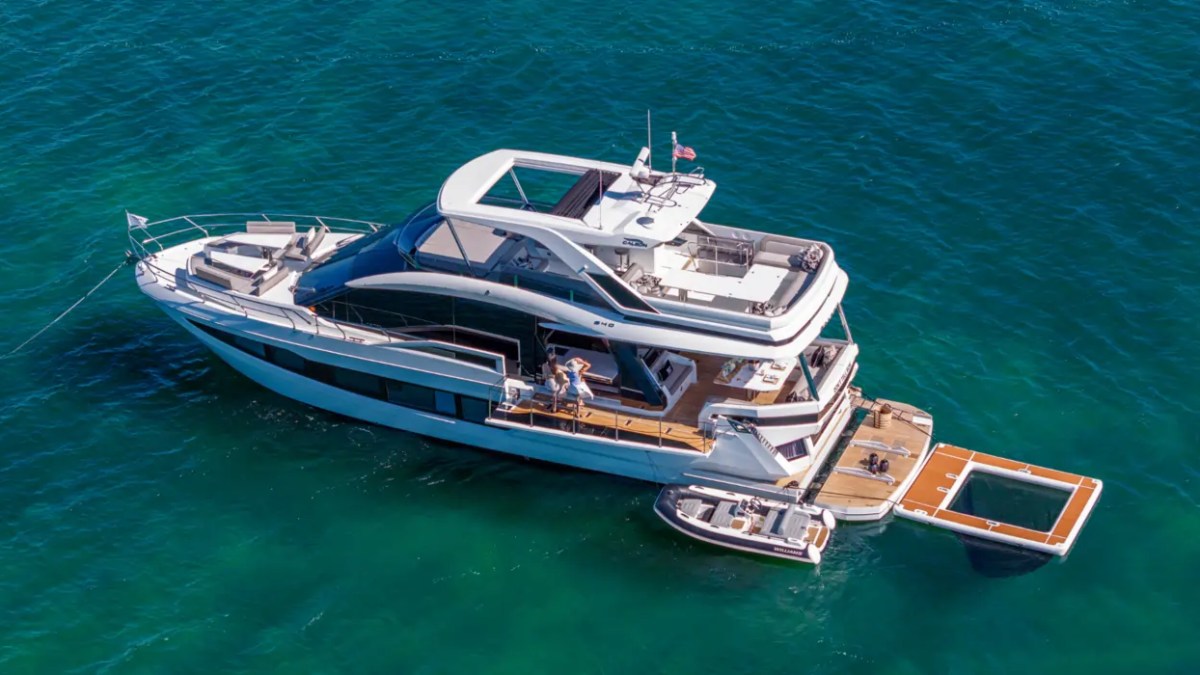 68' Galeon Yacht Charter captured from a waterfront aerial showcasing the flybridge foldout beach club terraces inflatable ocean pool and tender anchored off Key Biscayne on Biscayne Bay.