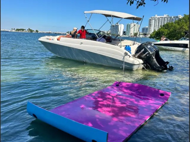 30' Hurricane Boat Rental anchored at a Miami sandbar with a floating Magic Carpet water mat.
