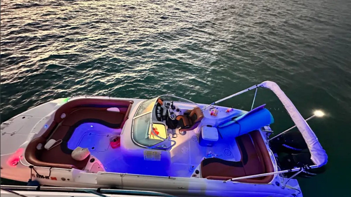 30' Hurricane Boat Rental illuminated at sunset with underwater lights in Biscayne Bay, Miami.