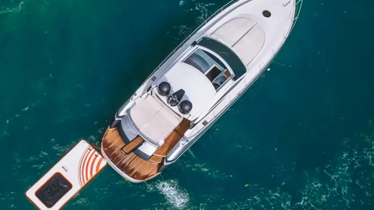 50' Pershing Yacht Charter aerial view with inflatable Magic Carpet floating platform in the clear waters of Miami.