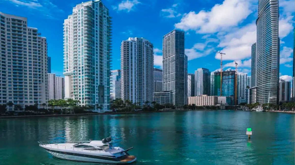 50' Pershing Yacht Charter anchored in Brickell Miami with luxury waterfront skyscrapers along the Miami River.