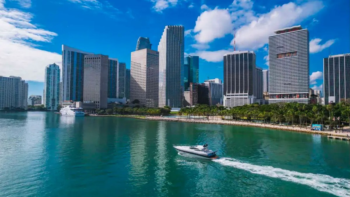 50' Pershing Yacht Charter cruising past the Downtown Miami skyline on Biscayne Bay during a luxury private yacht experience.