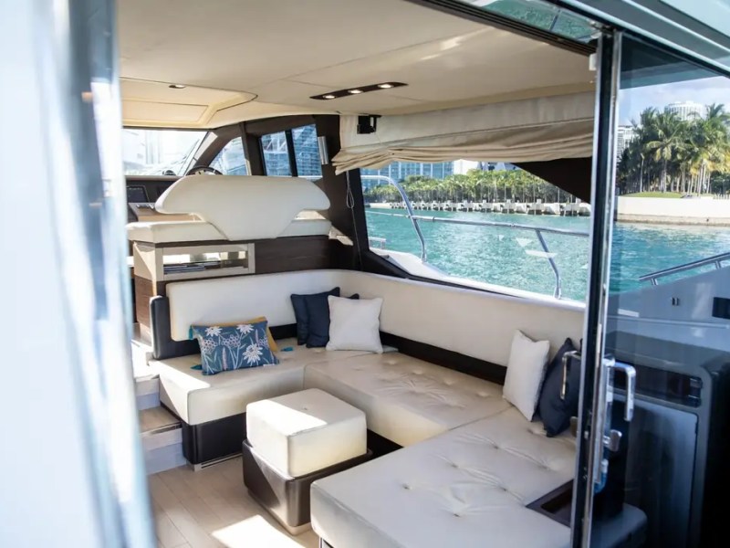 Salon lounge aboard a 52' Azimut Yacht Charter featuring plush seating, panoramic windows and luxury comfort in Miami.