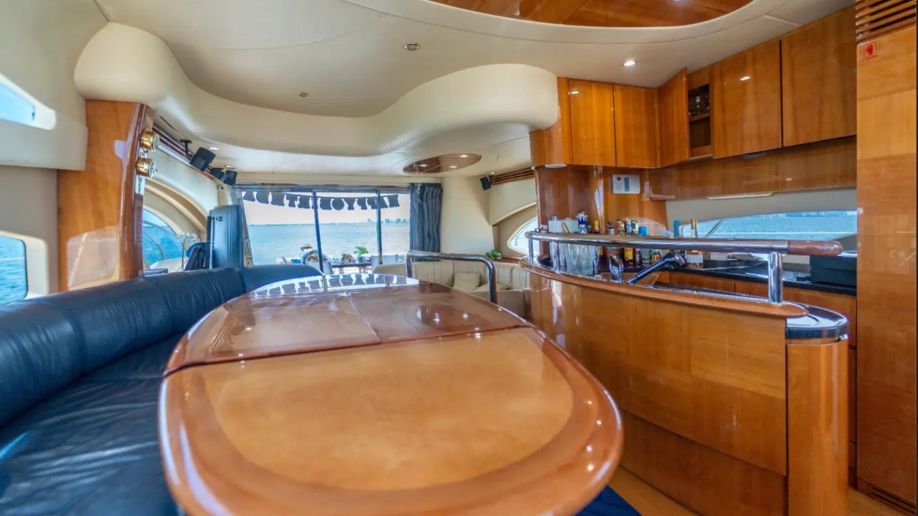 65' Azimut Yacht Charter luxury salon with dining area and full galley in Miami.