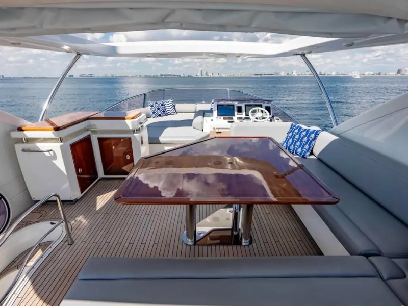 70' Azimut Yacht Charter flybridge dining area with helm, wet bar and panoramic Miami ocean views.