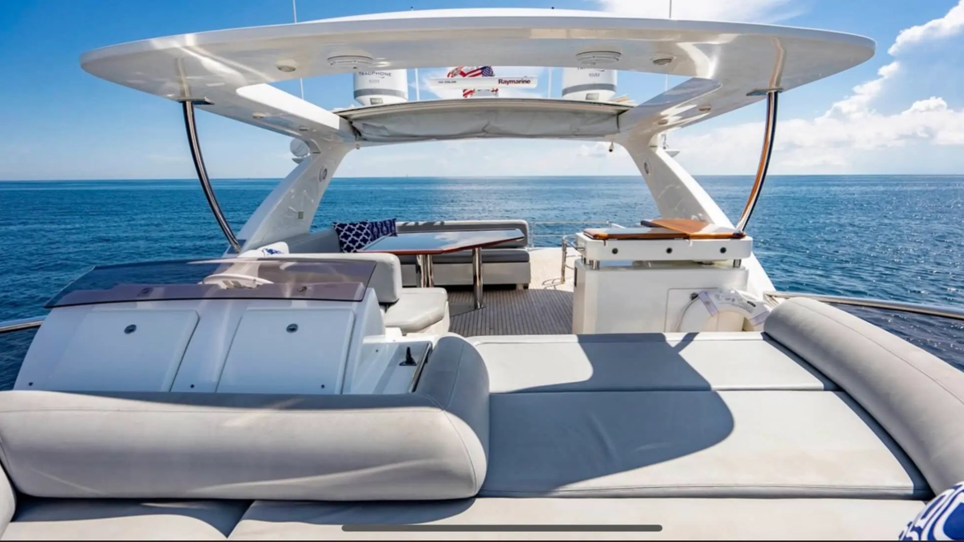 70' Azimut Yacht Charter flybridge lounge with sun pad, helm station and panoramic ocean views in Miami.