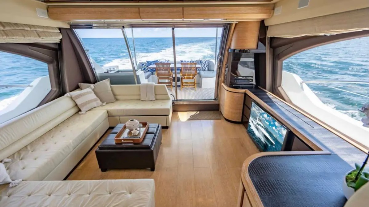 70' Azimut Yacht Charter luxury salon with panoramic windows, plush seating and aft deck access in Miami.