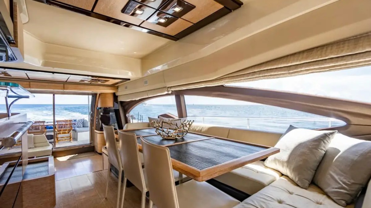 70' Azimut Yacht Charter luxury salon with dining area, panoramic windows and ocean views in Miami.