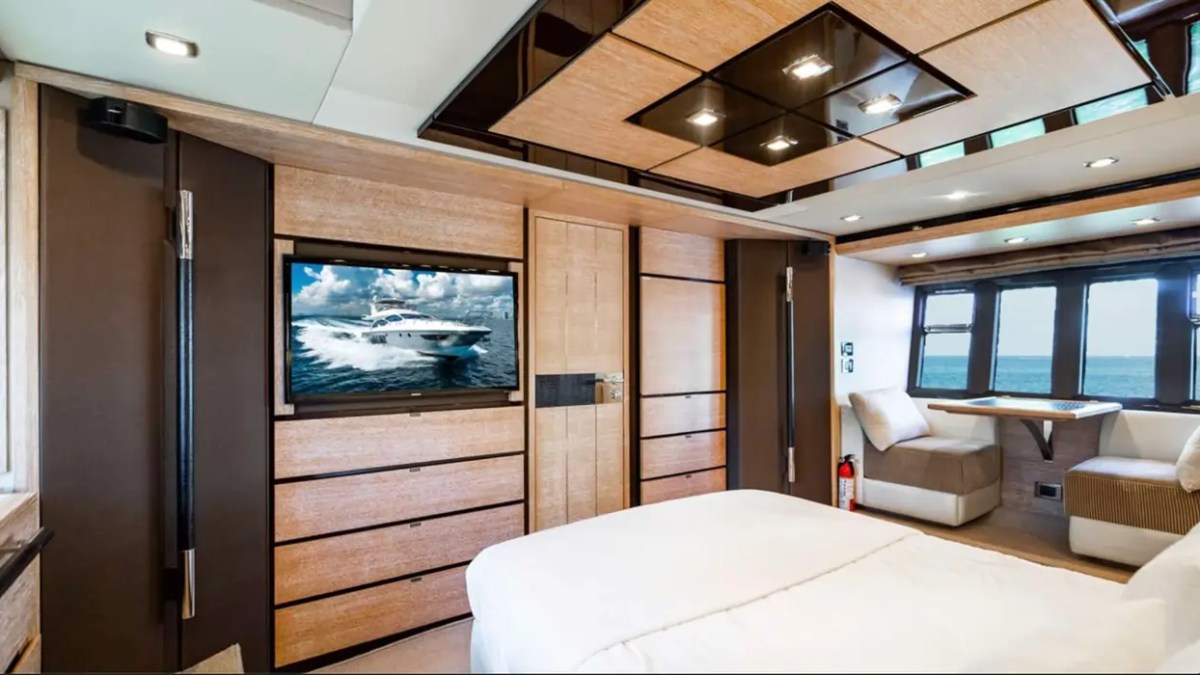 70' Azimut Yacht Charter full-beam master stateroom with entertainment center, lounge seating and panoramic ocean views in Miami.