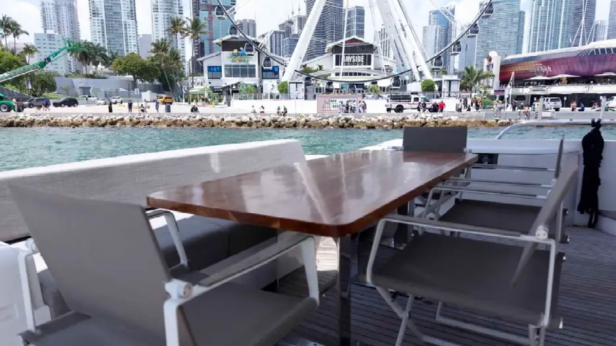 80' Ferretti Yacht Charter aft cockpit dining area with waterfront views in Miami.
