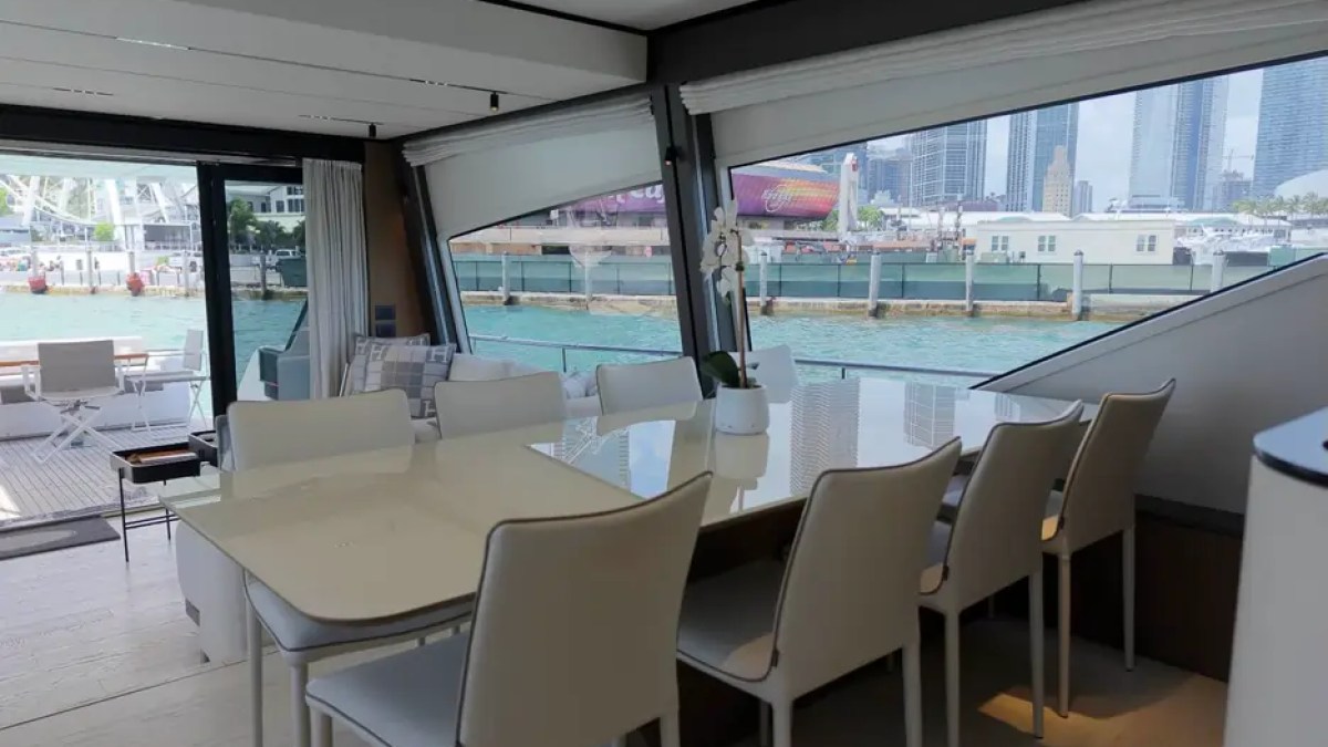 80' Ferretti Yacht Charter spacious formal dining area with panoramic Miami waterfront views.