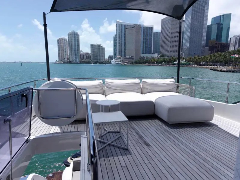 80' Ferretti Yacht Charter upper deck lounge with Miami skyline views and luxury outdoor seating.