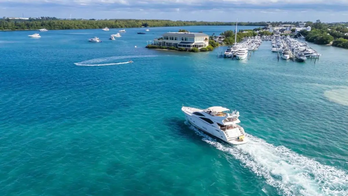 90' Azimut Yacht Charter cruising near a Miami marina on the turquoise waters of Biscayne Bay.
