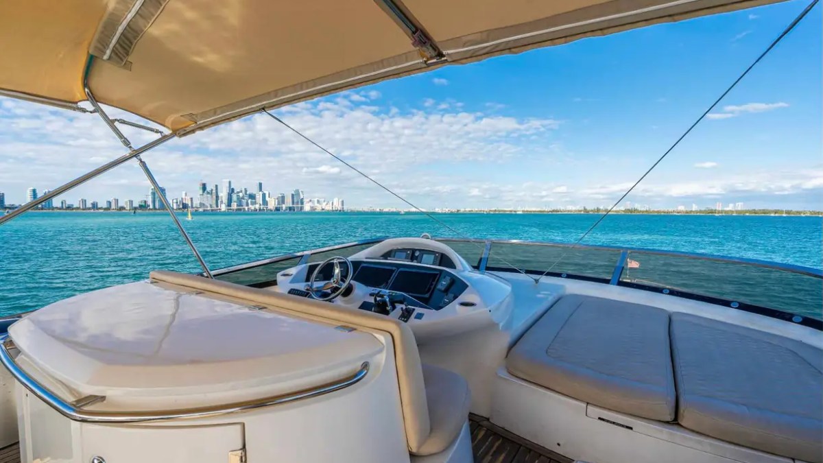 90' Azimut Yacht Charter flybridge helm with sun pad and panoramic Miami Bay views.