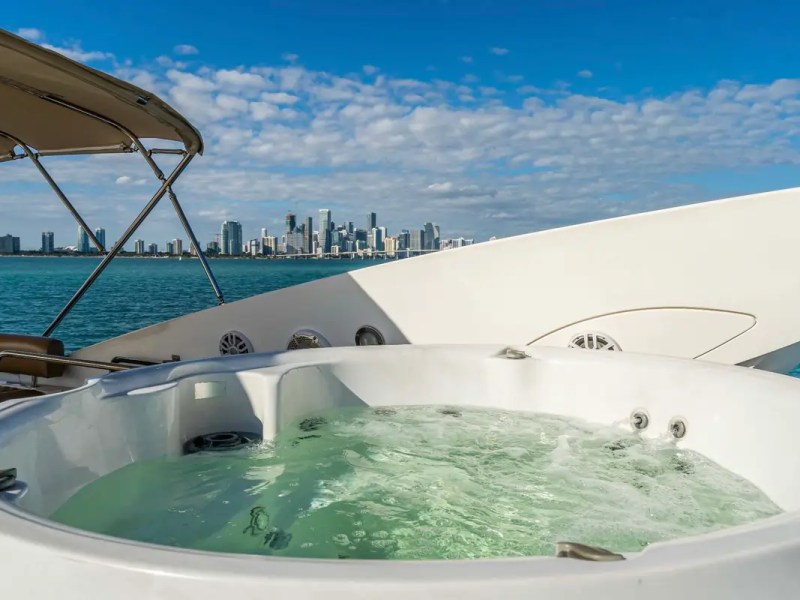 90' Azimut Yacht Charter featuring a luxury jacuzzi on the flybridge with panoramic Miami skyline views.