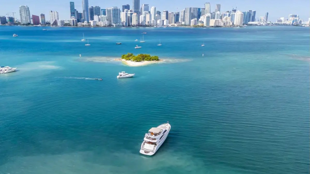 90' Azimut Yacht Charter anchored near a Miami sandbar with the downtown skyline across Biscayne Bay.