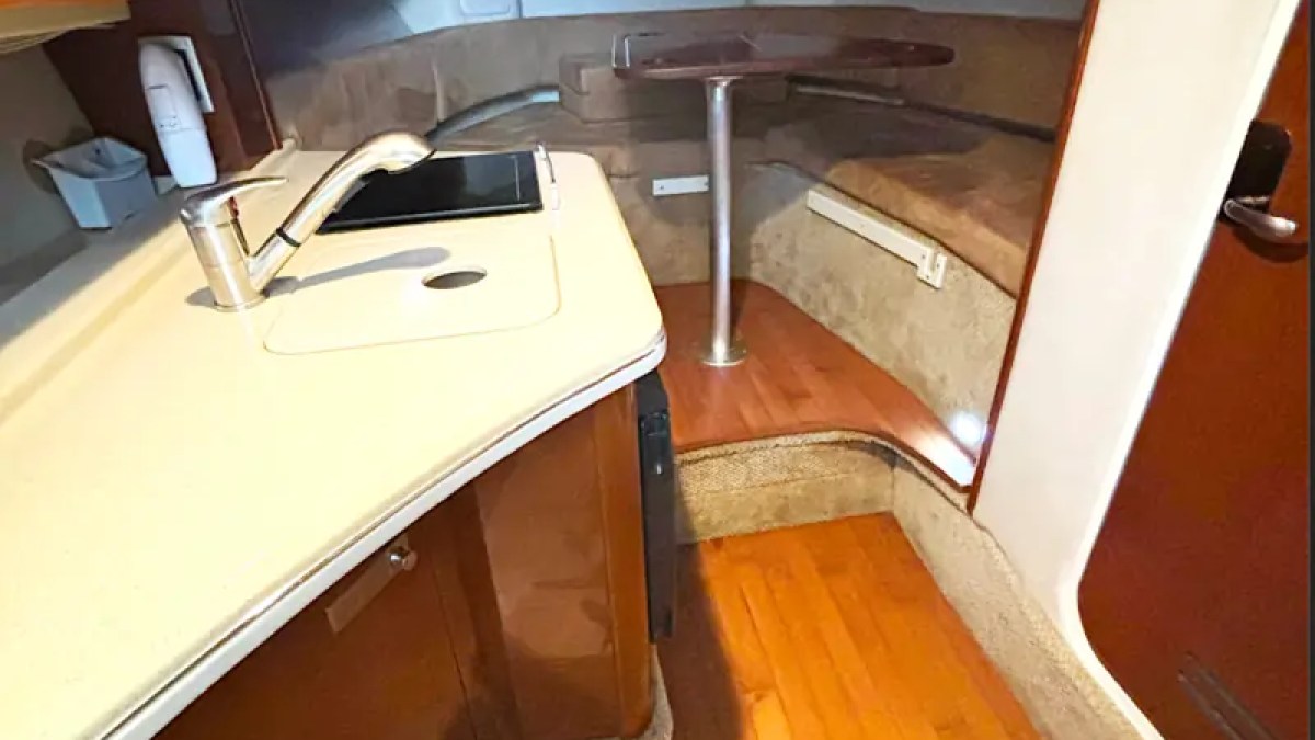 30' SeaRay Boat Rental cabin featuring a compact galley, wraparound lounge seating, and convertible dinette for relaxing while cruising Miami Beach and Biscayne Bay.