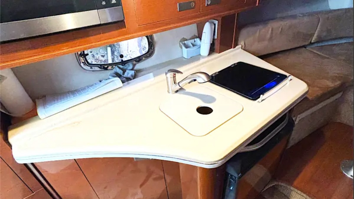 30' SeaRay Boat Rental galley featuring a compact kitchenette with sink, microwave, storage cabinets, and food preparation space for comfortable cruising from Miami Beach.