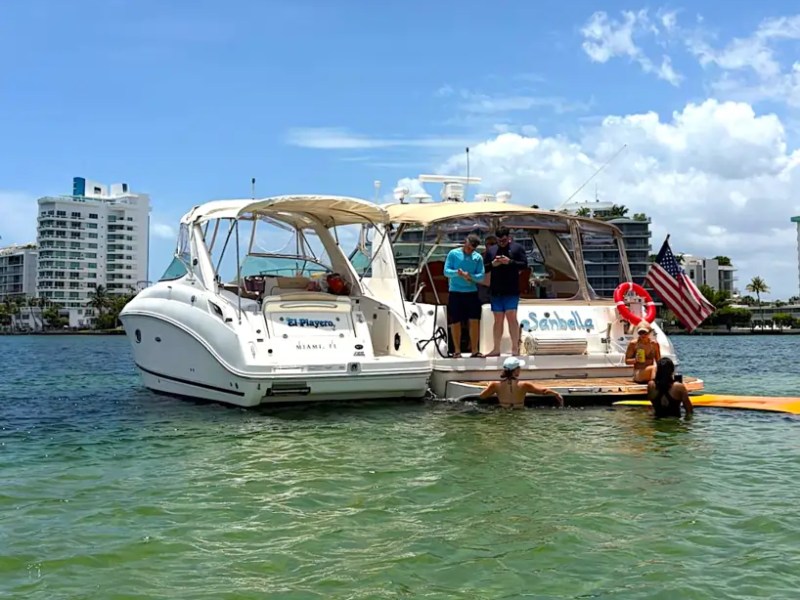 30' SeaRay Boat Rental anchored at a Miami Beach sandbar with guests enjoying the swim platform and crystal-clear waters during a fun day on Biscayne Bay.