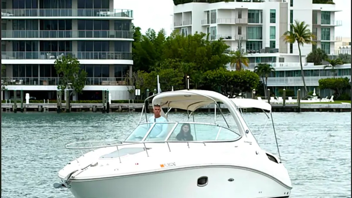 30' SeaRay Boat Rental cruising the scenic waterways of Miami Beach with luxury waterfront residences in the background, showcasing its sleek express cruiser design on Biscayne Bay.