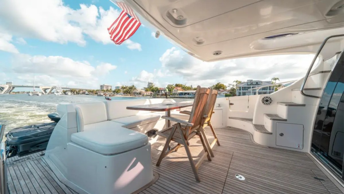 66' Azimut Yacht Charter spacious aft cockpit lounge with teak dining table in Miami Beach.