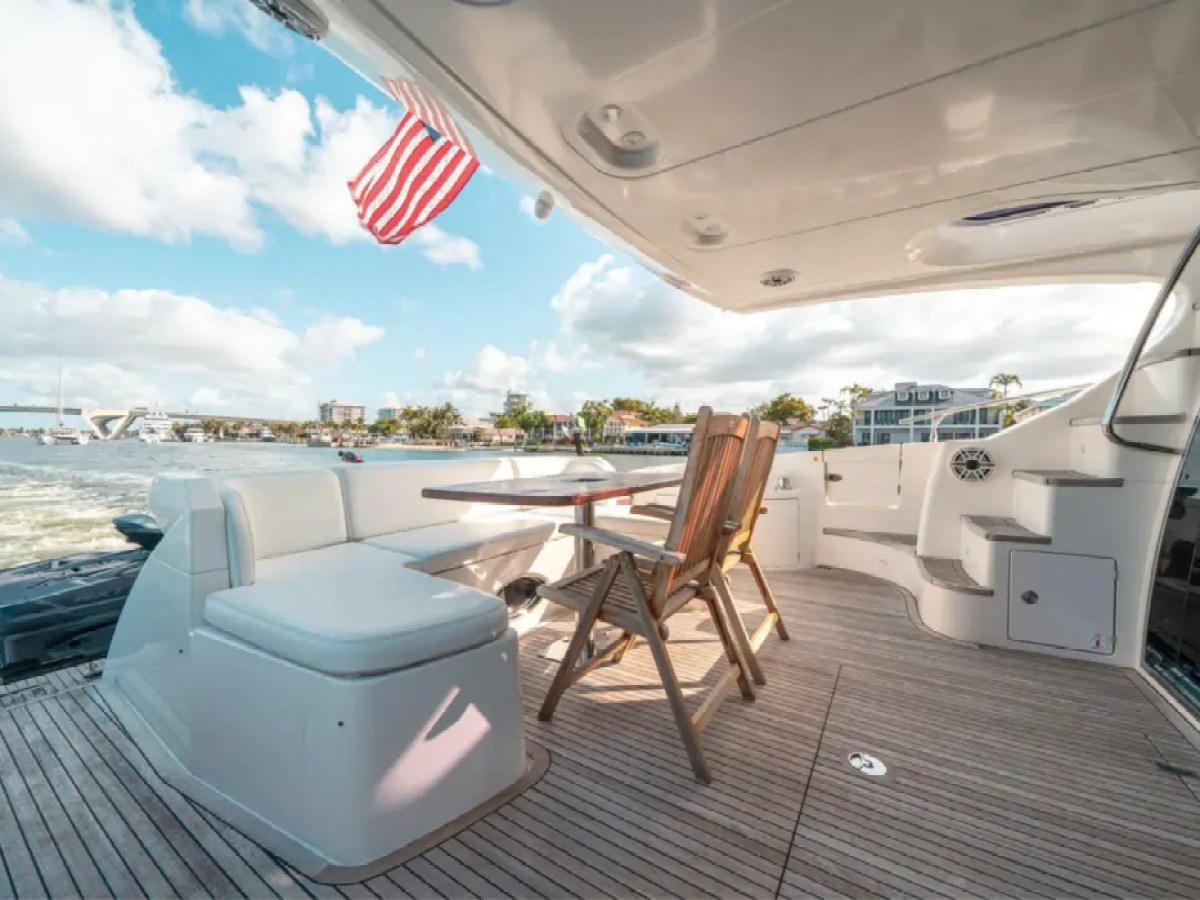 66' Azimut Yacht Charter spacious aft cockpit lounge with teak dining table in Miami Beach.
