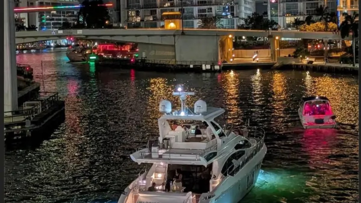 66' Azimut Yacht Charter cruising through Downtown Miami at night with underwater lights.