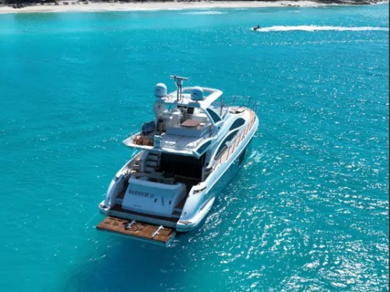 66' Azimut Yacht Charter anchored off a tropical beach in crystal-clear waters near Miami Beach.