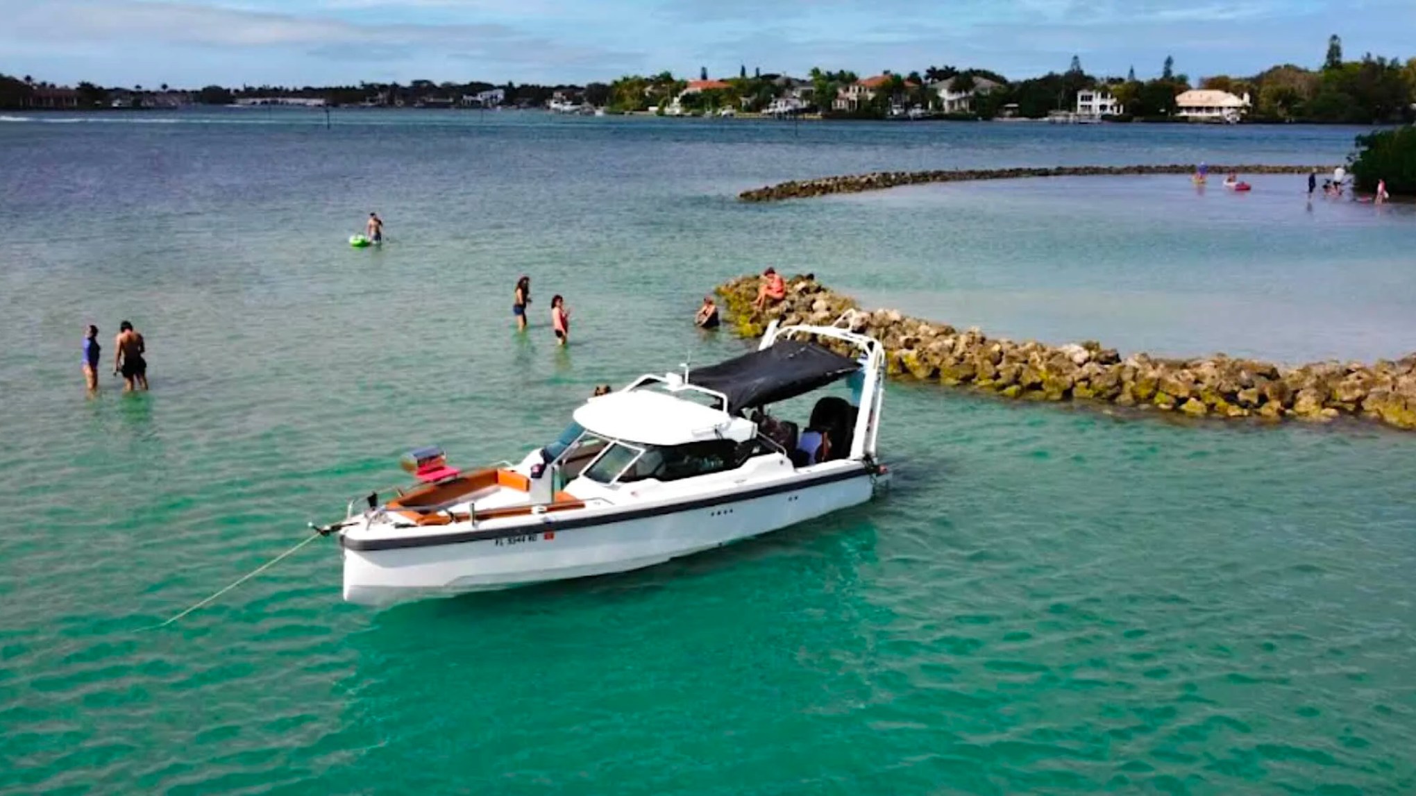 Aerial view of a 26' Axopar Boat Rental anchored in turquoise water near Peanut Island in Riviera Beach, Florida.