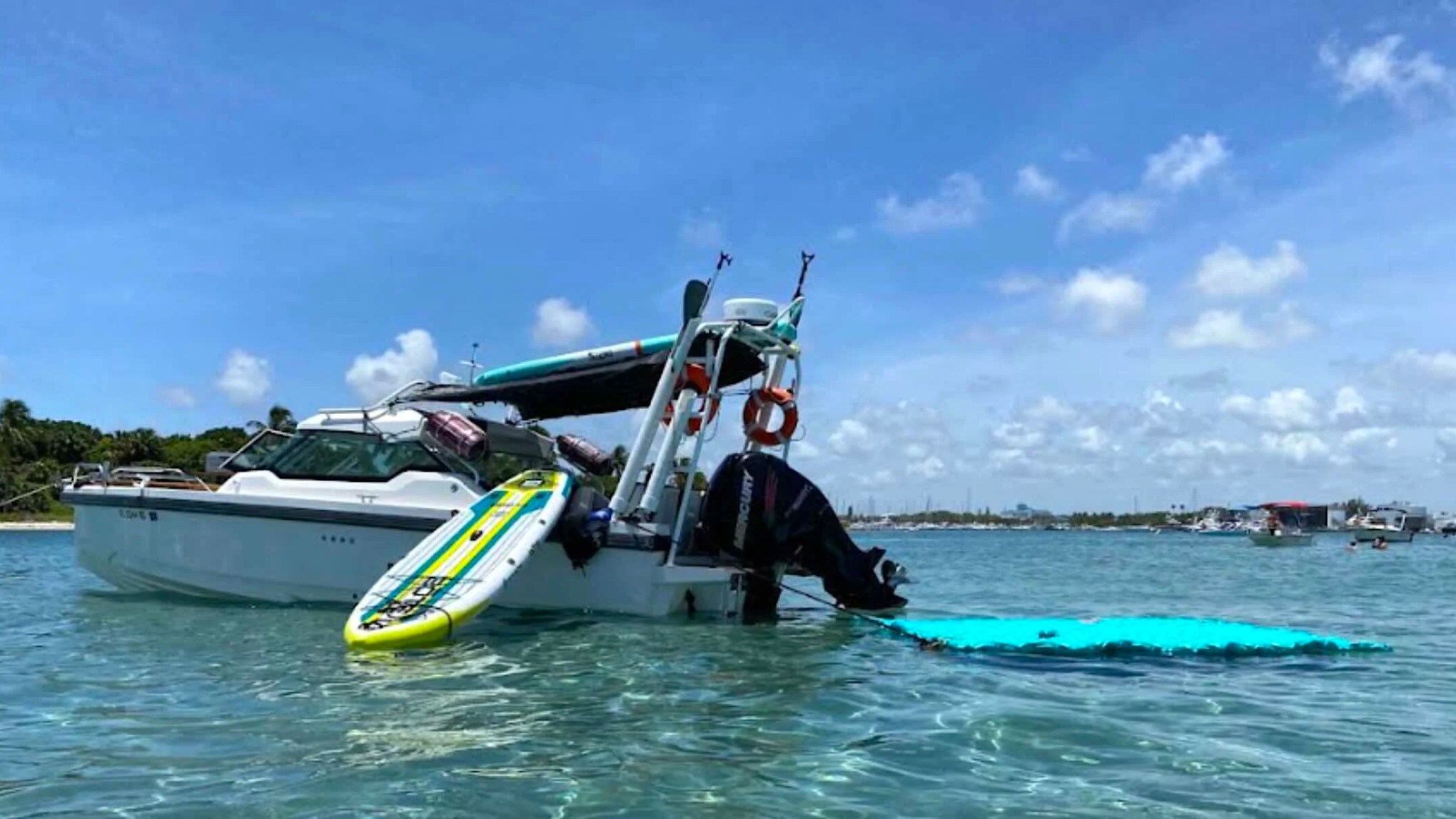 26' Axopar Boat Rental anchored with paddleboard and floating water mat near Peanut Island in Riviera Beach.