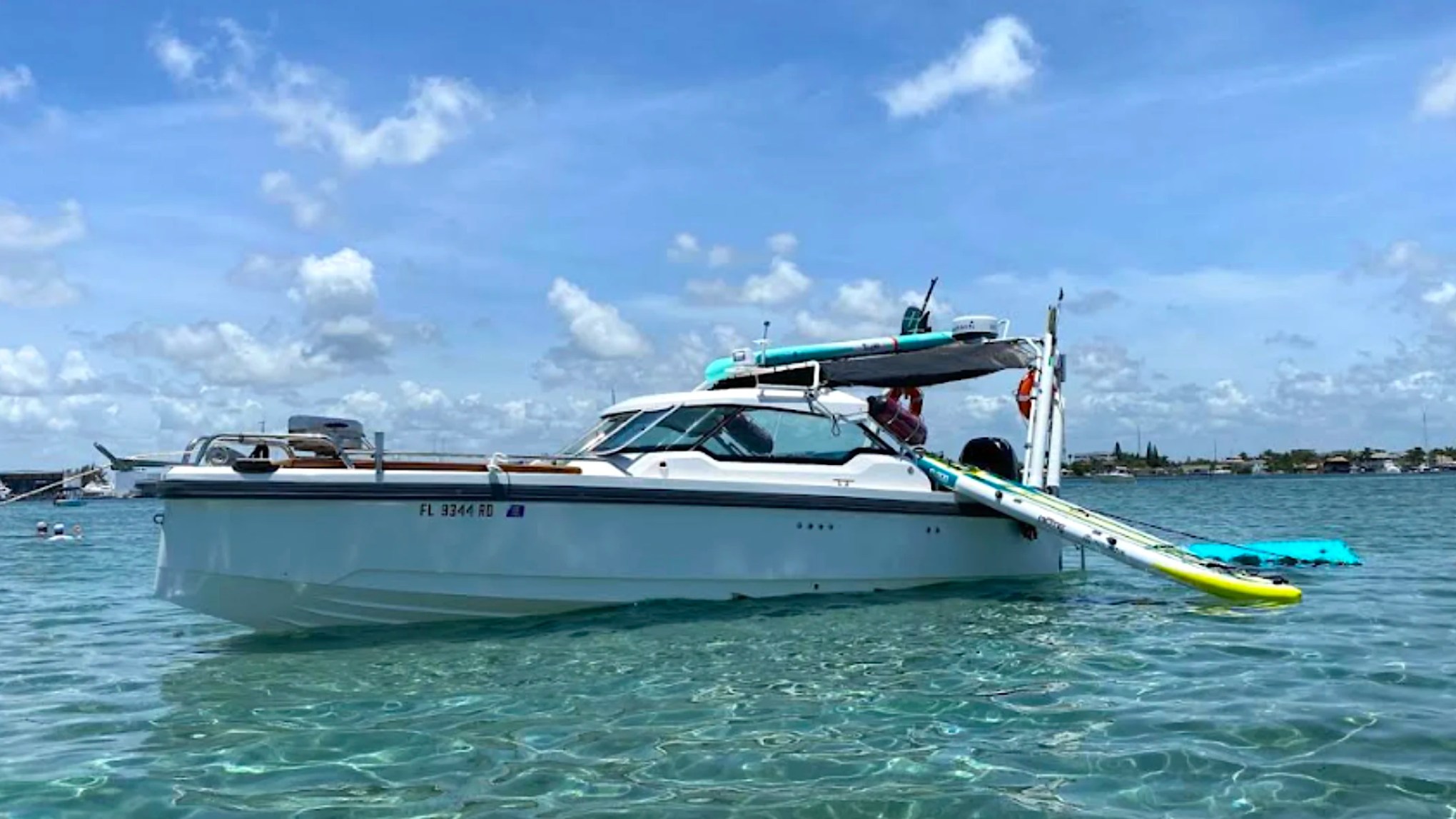 26' Axopar Boat Rental anchored in clear water with paddleboards and water toys near Peanut Island in Riviera Beach.