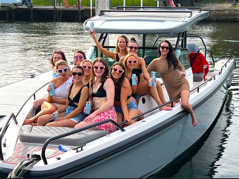Group celebrating aboard a 37' Axopar Boat Rental docked in Riviera Beach.