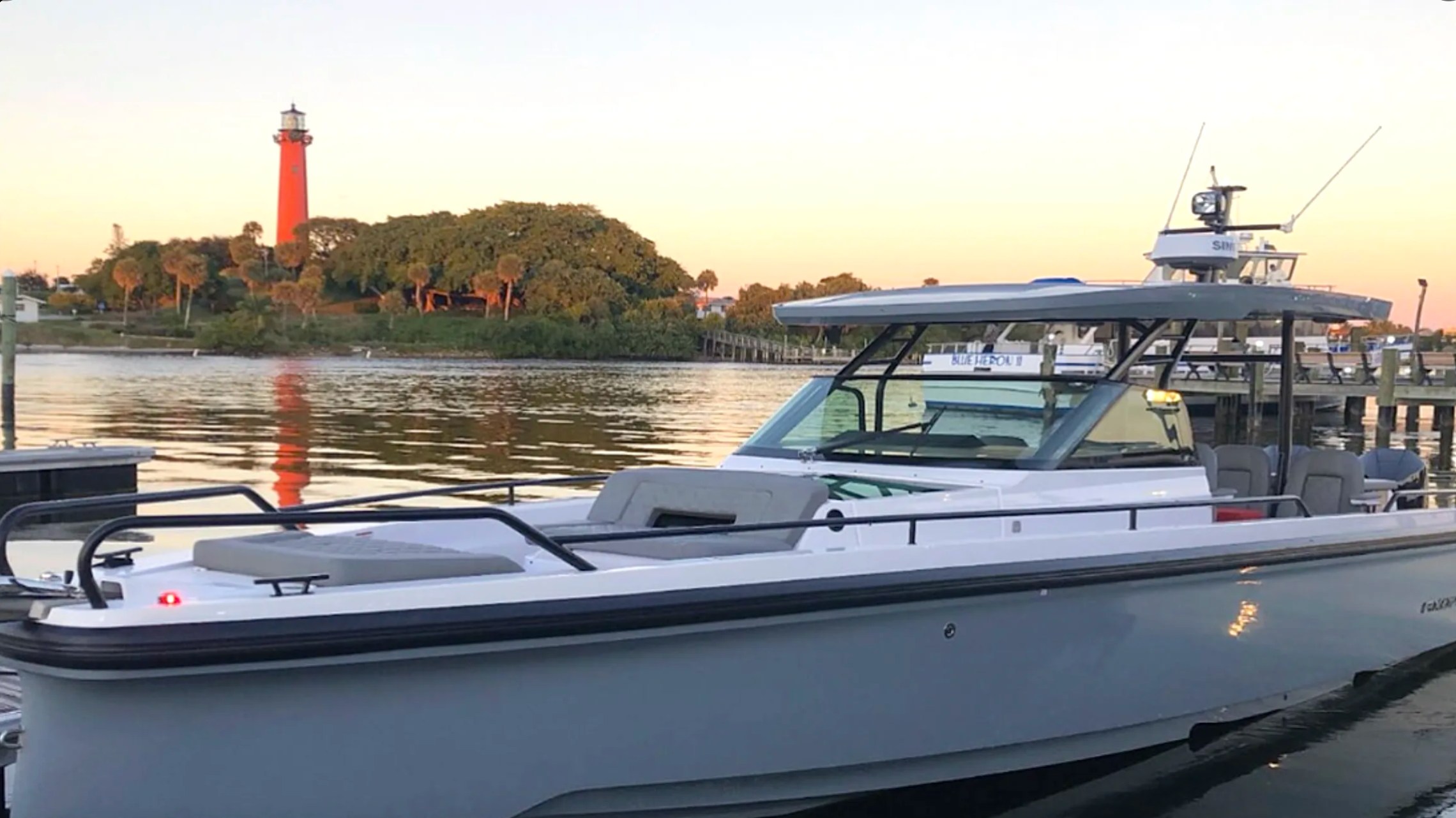 37' Axopar Boat Rental docked near Jupiter Inlet Lighthouse in Riviera Beach at sunset.