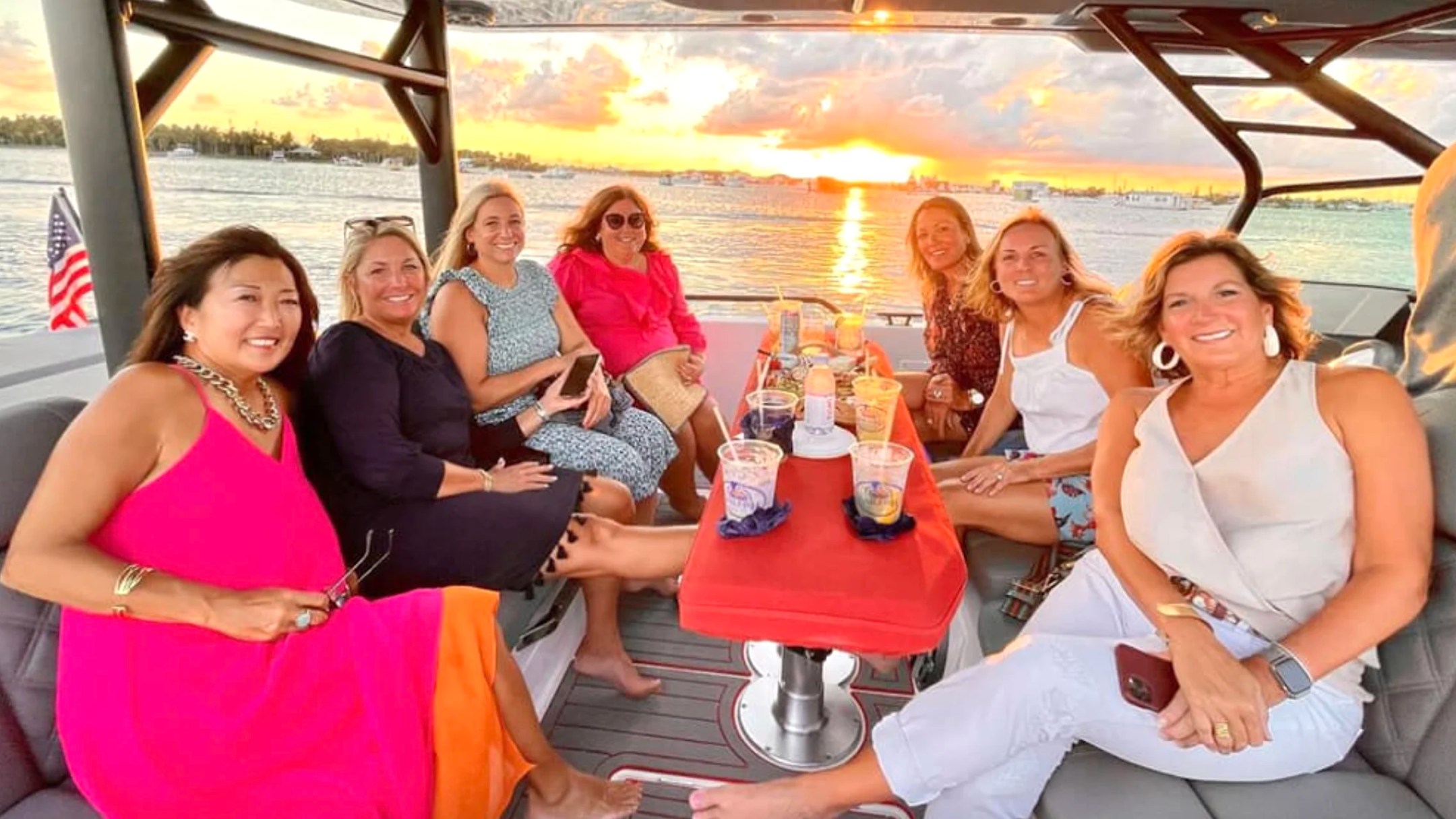 Friends enjoying sunset drinks aboard a 37' Axopar Boat Rental during a Riviera Beach boating adventure.