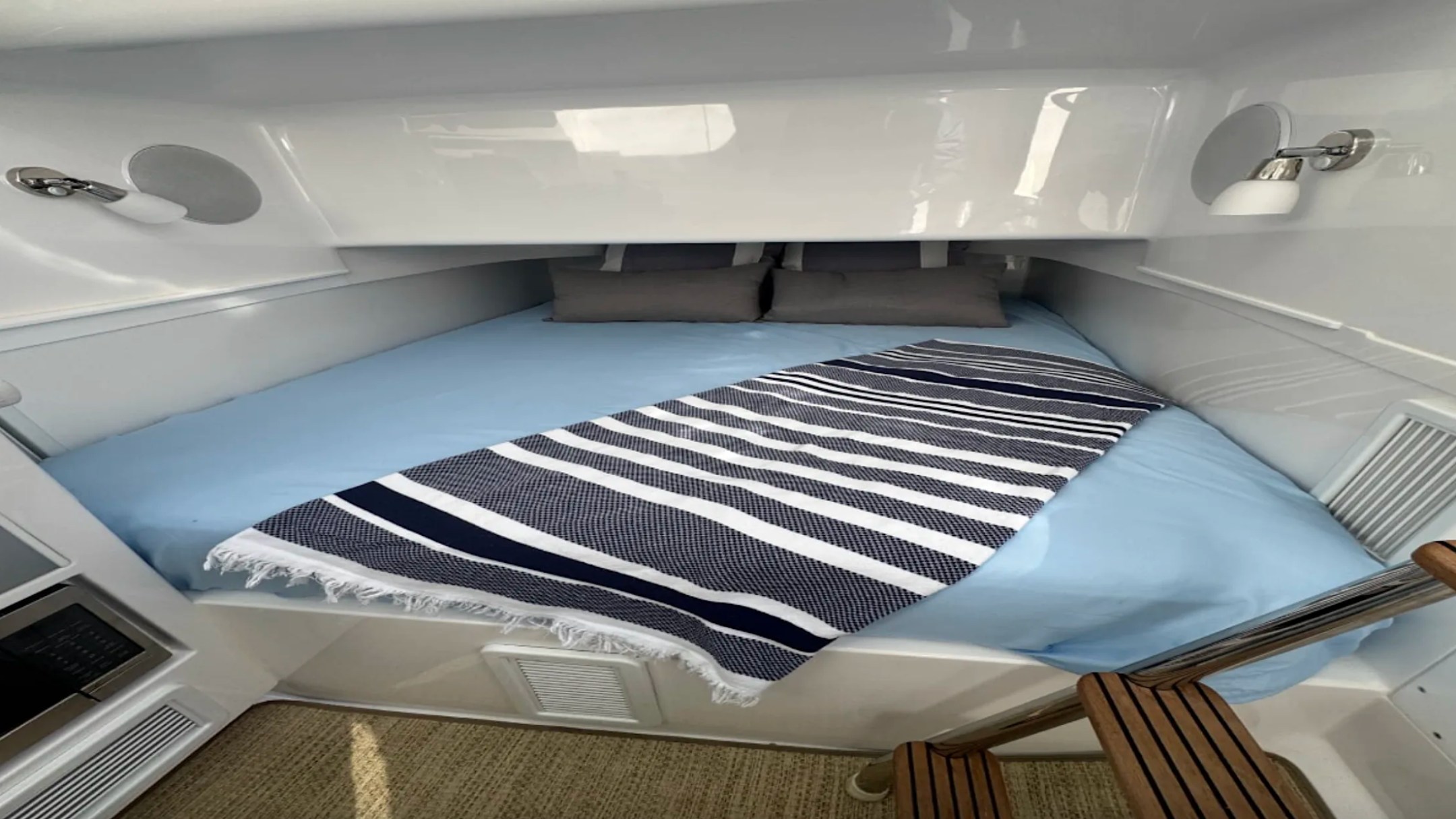 Private cabin aboard the 43' Mag Bay Boat Rental in Riviera Beach with a queen berth for relaxing between adventures.