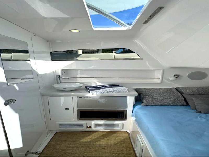Private cabin aboard a luxury Palm Beach Fishing Charter boat with berth, galley, and enclosed head.