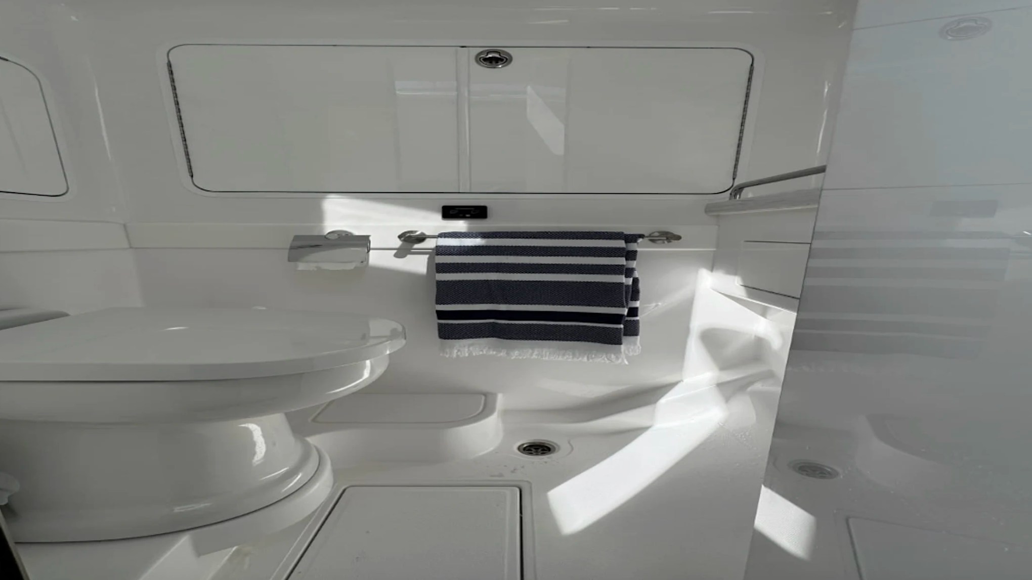 Private head aboard the 43' Mag Bay Boat Rental in Riviera Beach with a modern enclosed restroom for added comfort.
