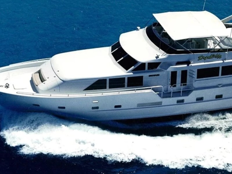 Aerial view of a 100' Broward Yacht Charter cruising through the waters of Fort Myers showcasing the classic flybridge design and spacious foredeck against the Gulf of America.