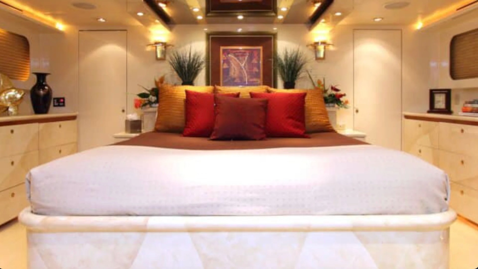 Luxurious full-beam master suite aboard the 100' Broward Yacht Charter in Fort Myers featuring a king berth, elegant lighting, custom cabinetry and refined yacht accommodations.