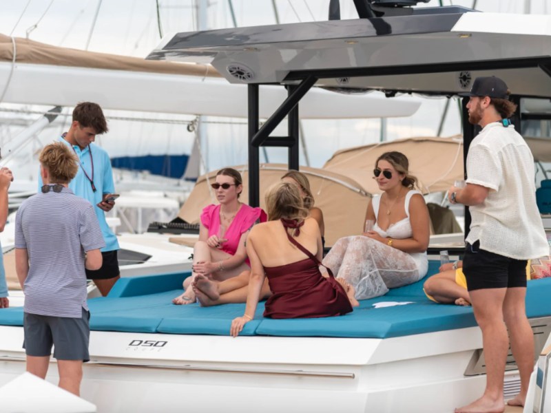 Guests relaxing on the expansive aft lounge of a 50' DeAntonio Yacht Charter at a Palm Beach marina before departing for a luxury cruise along South Florida waters.