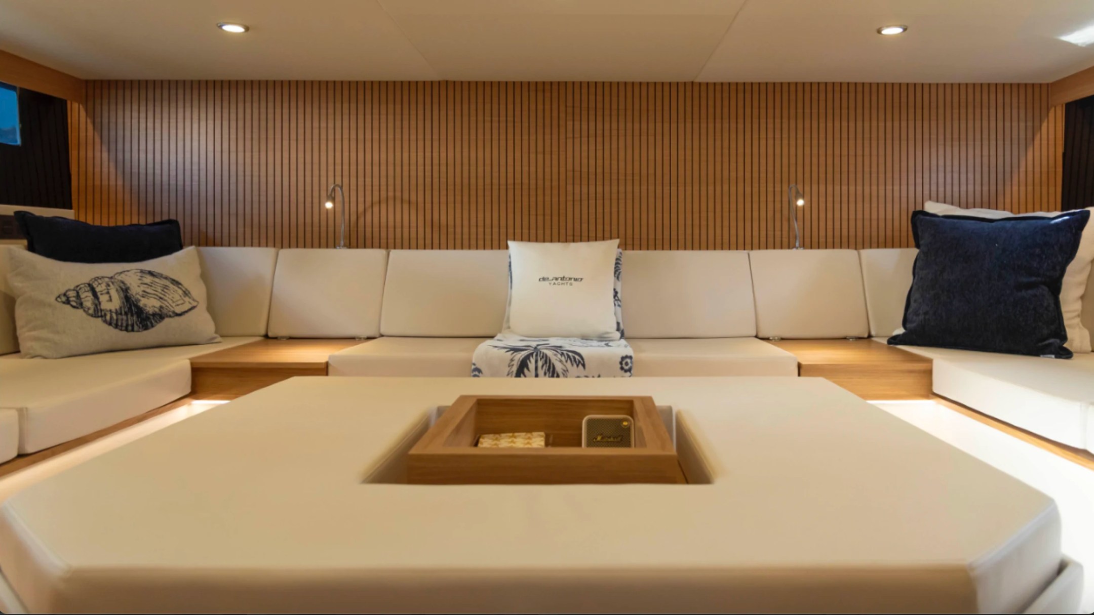 Spacious bow lounge aboard a 50' DeAntonio Yacht Charter in Palm Beach featuring premium cushioned seating, elegant teak accents and contemporary luxury yacht design.
