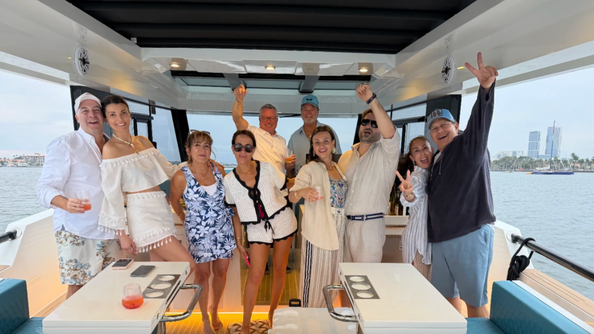 Guests celebrating aboard a 50' DeAntonio Yacht Charter in Palm Beach with panoramic views of the Intracoastal Waterway and spacious open-air lounge seating.
