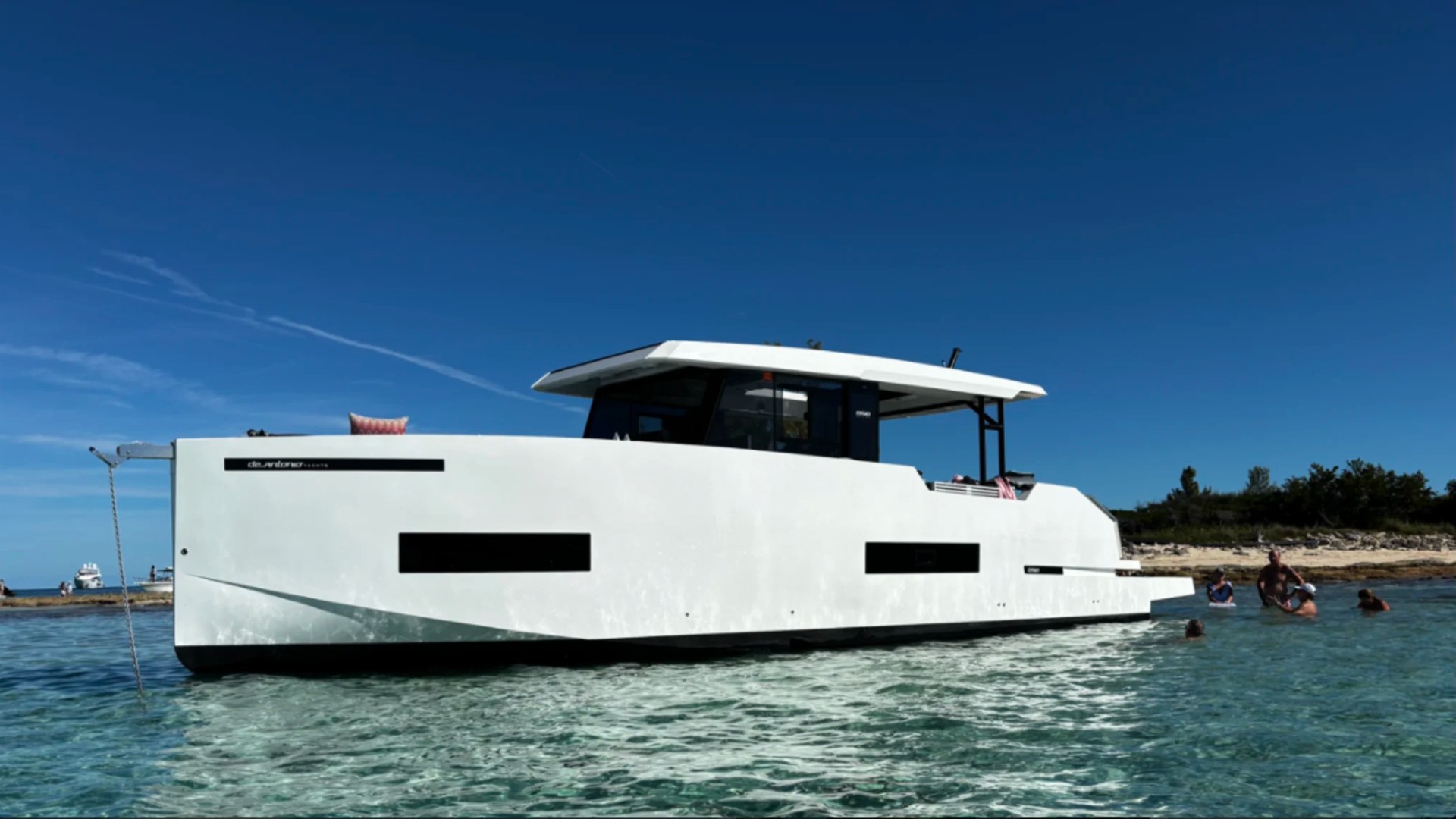 50' DeAntonio Yacht Charter anchored in the crystal-clear waters of Palm Beach near a popular sandbar showcasing its sleek European profile and modern design.