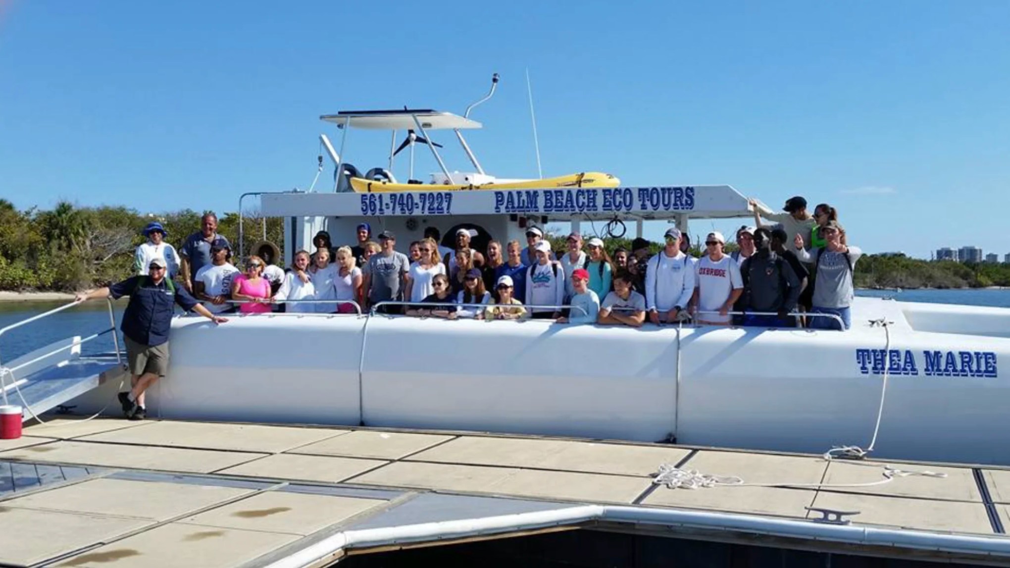 Guests posing aboard a 49' PowerCat Boat Rental before an eco tour in Riviera Beach Florida.
